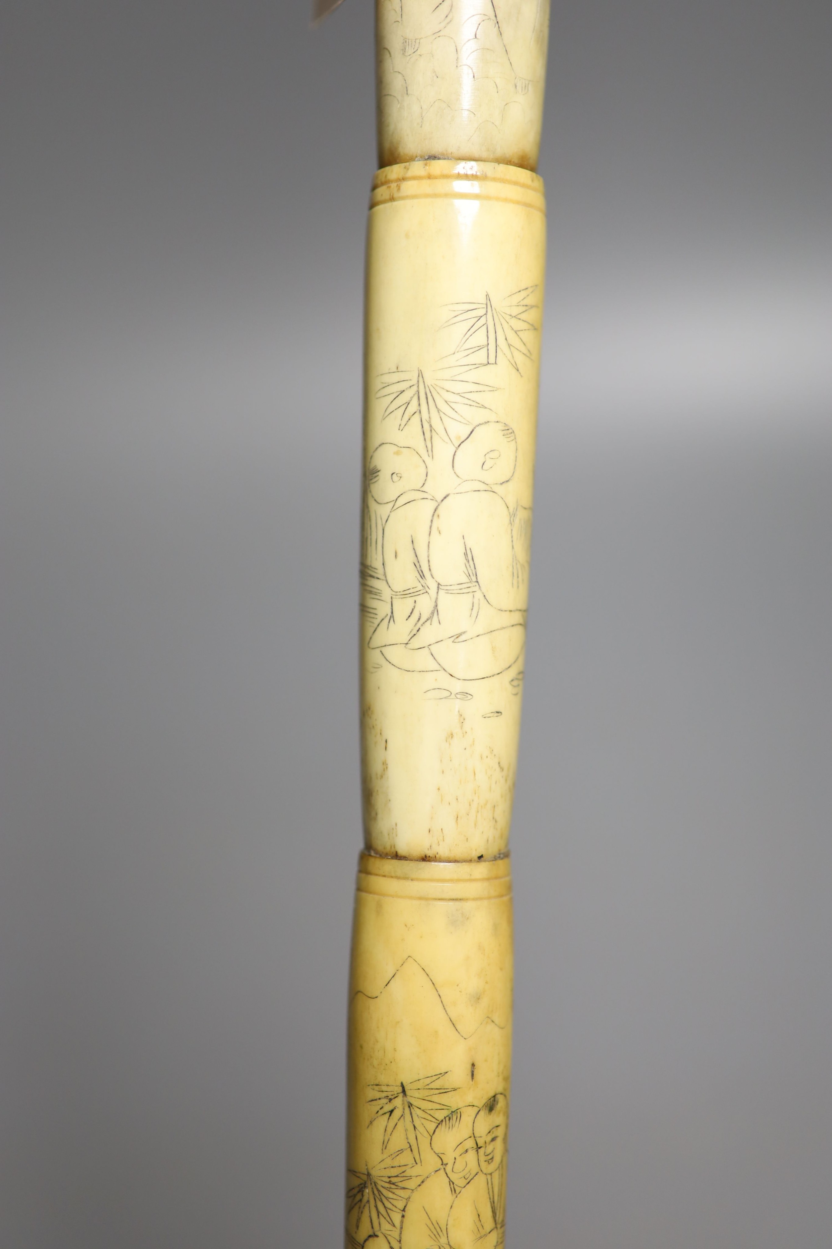 A Chinese engraved bone walking cane, 84cm